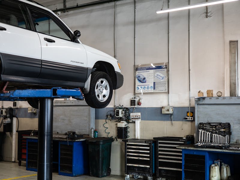 Vehicle elevated on lift for suspension inspection and repair